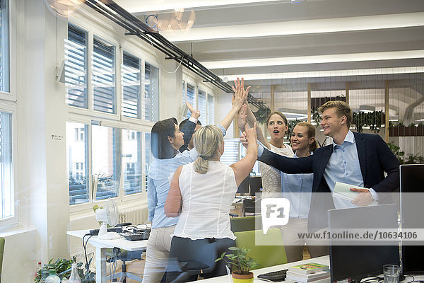 Successful business team high fiving in office