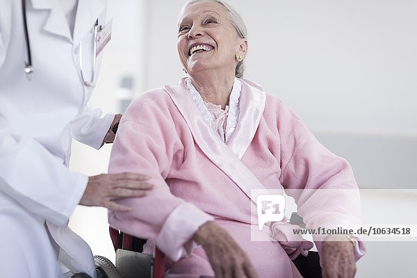 Doctor and smiling elderly patient in wheelchair