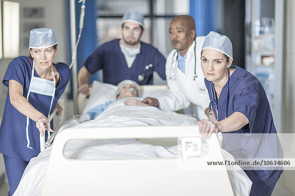 Doctors pushing a bed with patient