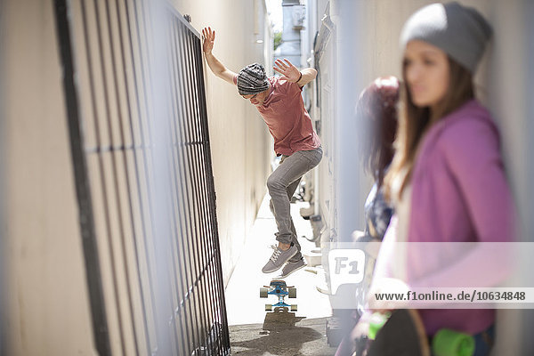 Junger Mann  der einen Skateboardtrick in einem Gang macht.