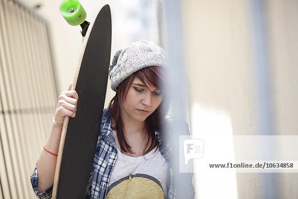 Junge Frau mit Skateboard im Freien