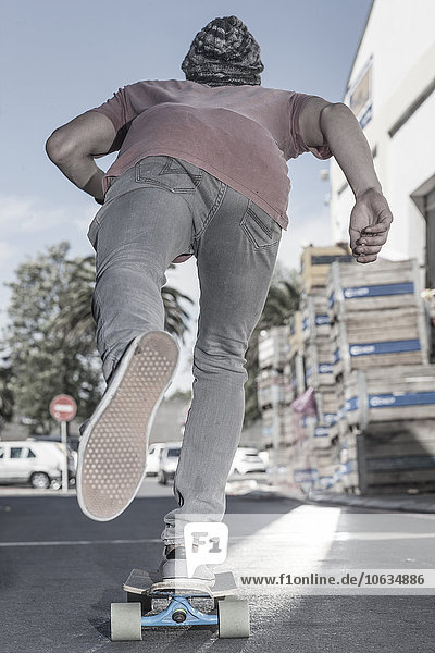 Rückansicht eines Skateboardfahrers auf der Straße