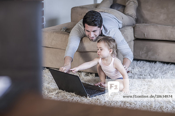 Vater und kleines Mädchen schauen auf den Laptop