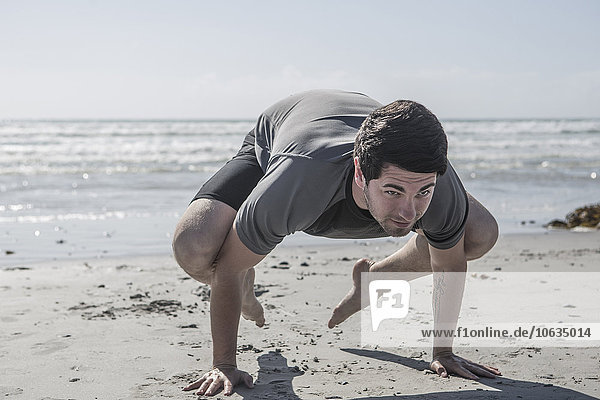 Young man exercising on beach