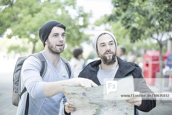 Young men in the city with map looking for directions