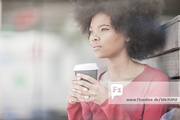 Woman holding cup of coffee  looking at distance