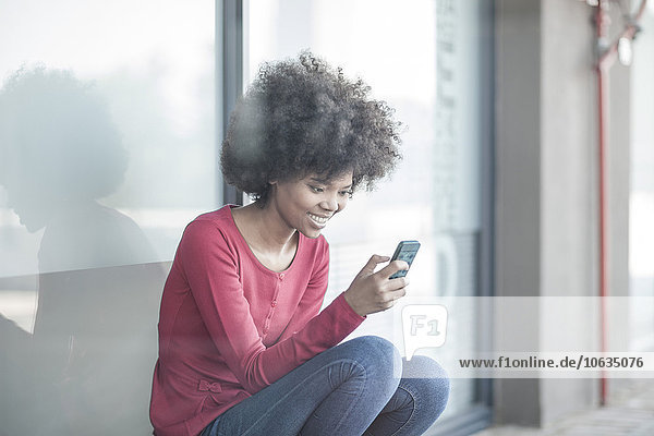 Young woman reading messages on smart phone