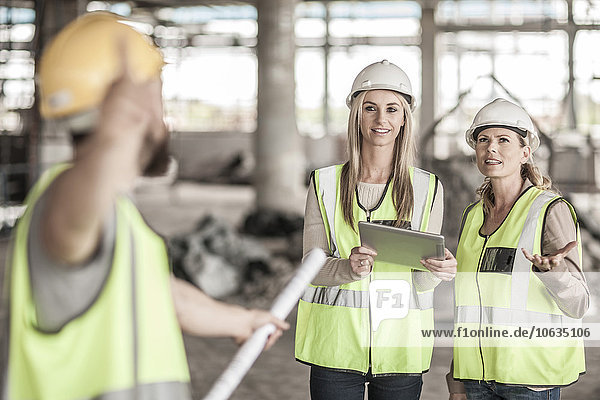 Zwei Frauen in Schutzkleidung und Bauarbeiterinnen auf der Baustelle