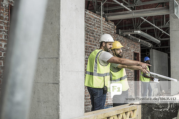 Bauarbeiter diskutieren auf der Baustelle