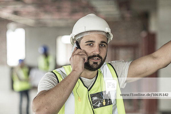 Bauarbeiter auf dem Handy auf der Baustelle