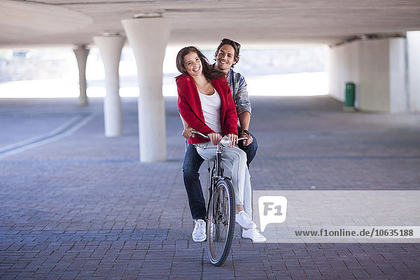Glückliches Paar beim Fahrradfahren im Parkhaus
