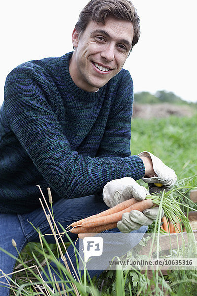 Mann bei der Karottenernte im Feld  Porträt
