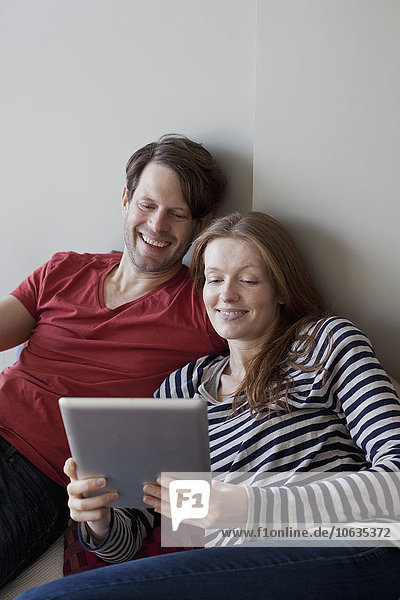 Couple using digital tablet  smiling