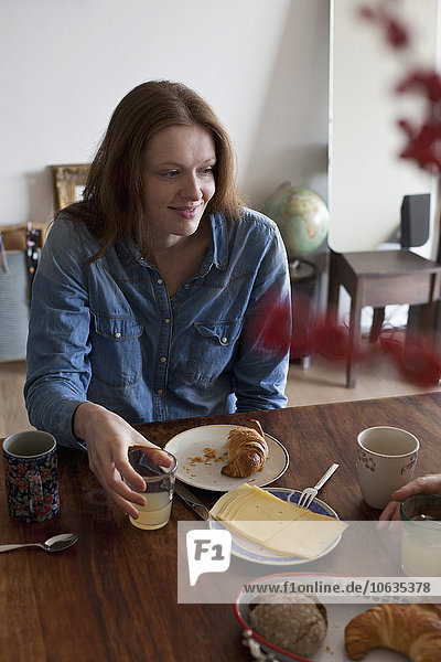 Woman having breakfast at dining table