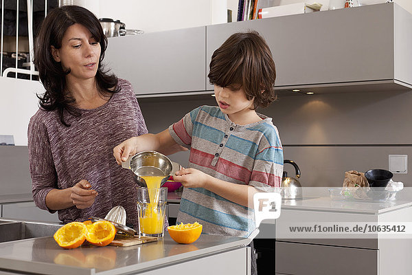 Mother and son making orange juice