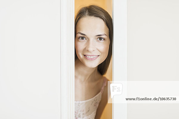 Porträt einer schönen Frau  die lächelt  während sie durch die Türen schaut.
