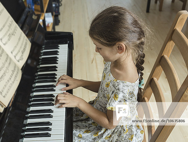 High angle view of girl playing piano at home