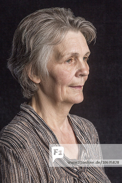 Nachdenkliche Seniorin vor schwarzem Hintergrund