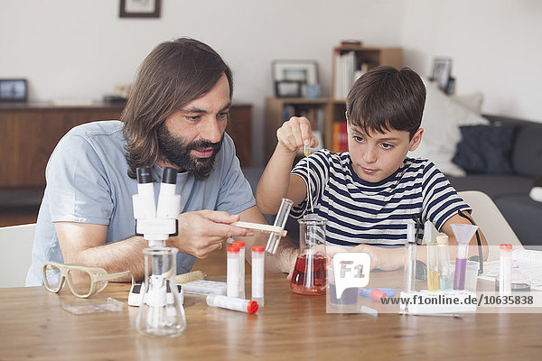 Vater und Sohn arbeiten zu Hause am wissenschaftlichen Experiment