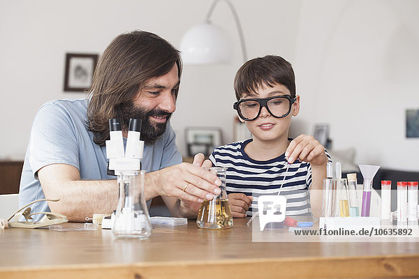 Vater und Sohn arbeiten zu Hause an einem schulwissenschaftlichen Projekt