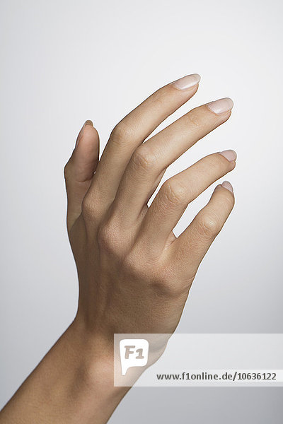 Cropped hand of woman against white background