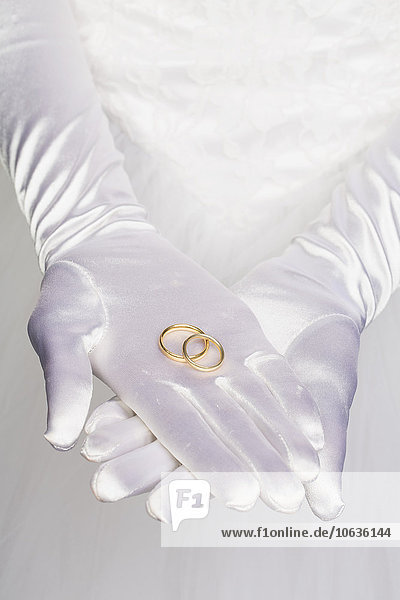 Midsection of bride holding wedding rings
