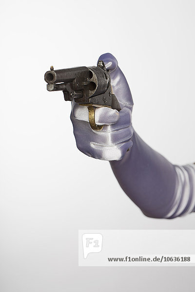 Bride's hand holding handgun against white background