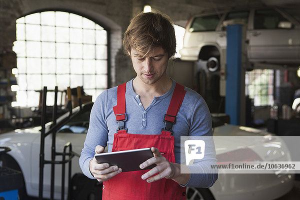 Mechanic using digital tablet at garage