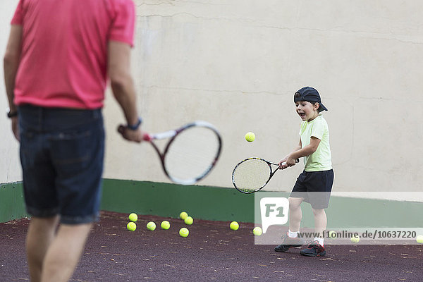 Vater und Sohn spielen Tennis auf dem Spielfeld