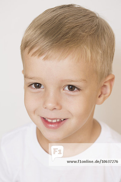 Portrait of smiling boy against white background