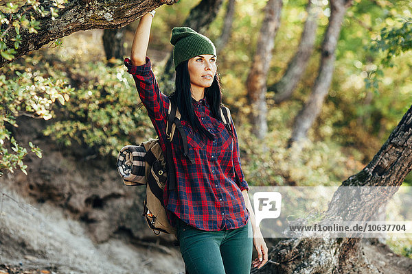 Thoughtful female hiker standing in forest