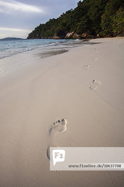 Hochwinkelansicht der Fußabdrücke auf Sand am Strand