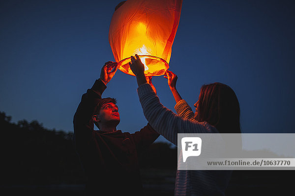 Low angle view of hikers releasing paper lanterns