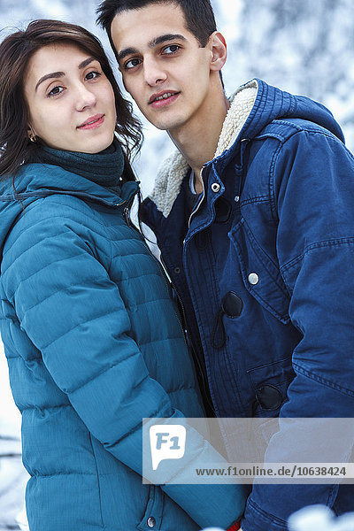 Loving young couple in warm clothing looking away