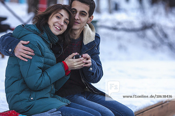 Portrait of romantic young couple having coffee during winter