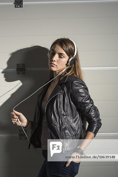 Entspannte Frau beim Musikhören über Kopfhörer im Musikstudio