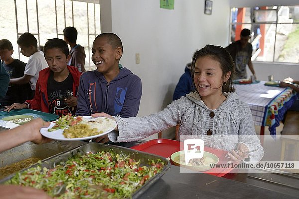 Girl receiving food at the food counter of a cafeteria  social project  Bogota  Colombia  South America