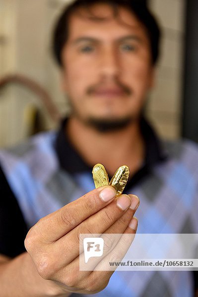 Mann mit zwei Stücken Gold in einem Laden  in dem Gold angekauft wird  Goldgräberstadt Laberinto bei Puerto Maldonado  Departamento Madre de Dios  Peru  Südamerika