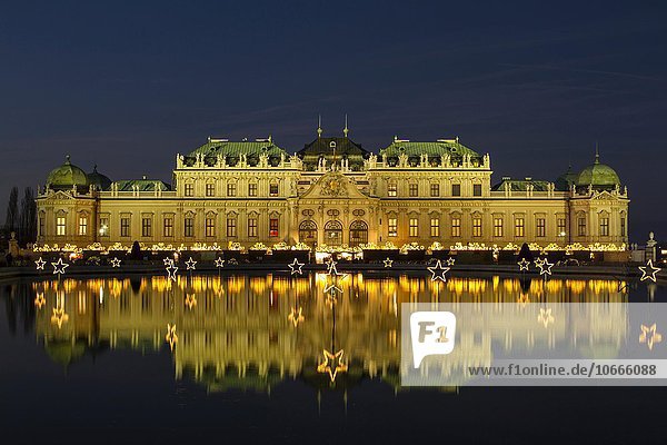 Christmas lights with Christmas Market in front of Belvedere Palace  reflection in the lake  Vienna  Austria  Europe