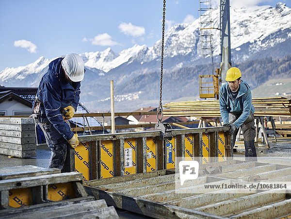 Construction workers lifting shuttering wall with crane  preparing framed formwork  Innsbruck Land  Tyrol  Austria  Europe