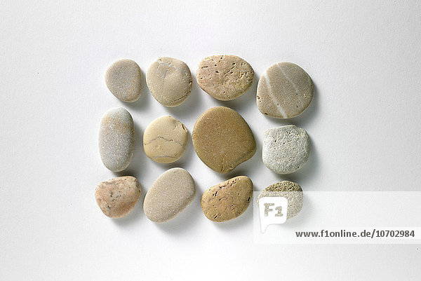 Komposition aus Steinen mit weißem Hintergrund.