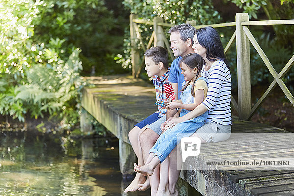Familie sitzt am Rande des Hafens