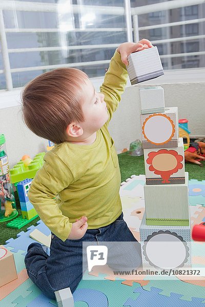 Baby Boy beim Stapeln von Spielblöcken zu Hause