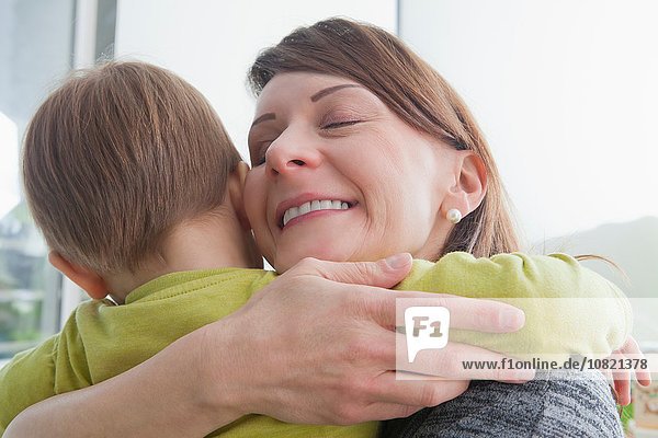 Mutter umarmt Sohn zu Hause