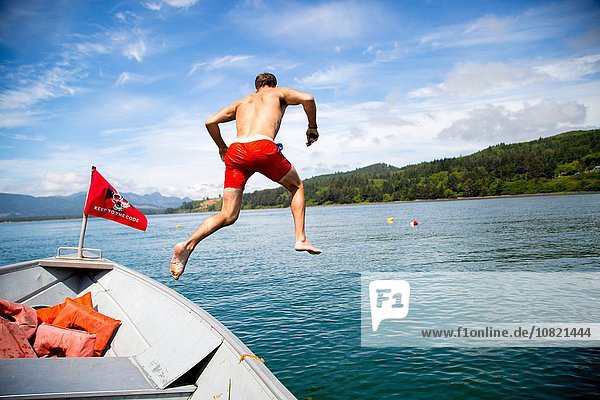 Mittlerer Erwachsener  der vom Boot ins Meer springt  Nehalem Bay  Oregon  USA