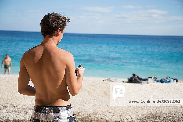 Rückansicht des nackten jungen Mannes am Strand  Golfo di Orosei  Sardinien  Italien