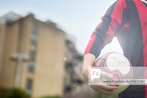 Junger Mann mit Fußball  Mittelteil