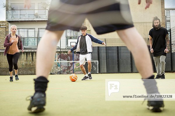 Gruppe von Erwachsenen  die auf dem Stadtfußballplatz Fußball spielen