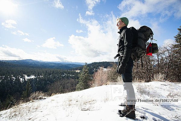 Young male hiker looking out from snow covered landscape  Ashland  Oregon  USA