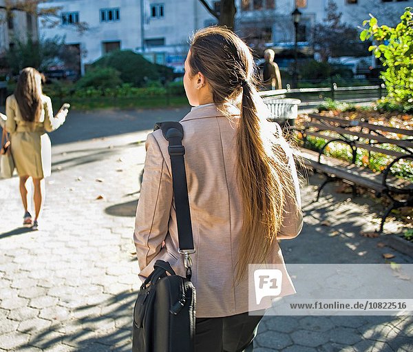 Rückansicht der jungen Frauen beim Spaziergang durch den Stadtpark
